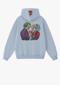 Hoodie celeste Mad Love con bordado de pareja estilo cómic, corazón roto y rosa en la capucha